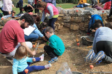 Famílies realitzant el taller d'arqueologia